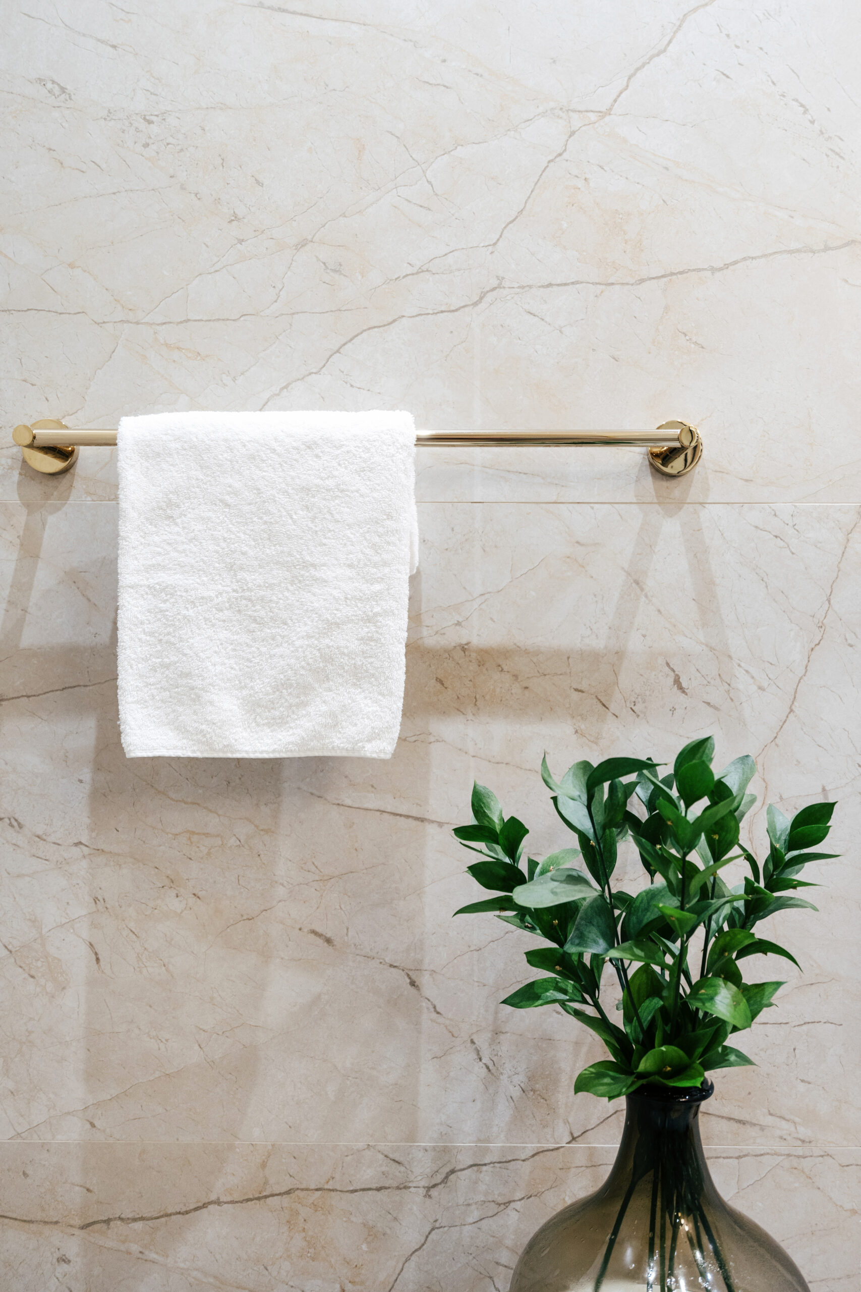 White bath towel hanging on rack in bathroom - bathroom hardware example