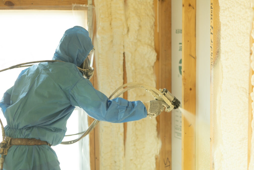 Technician spraying spray foam in a home.